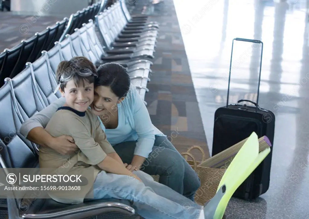 Woman sitting with son in airport lounge