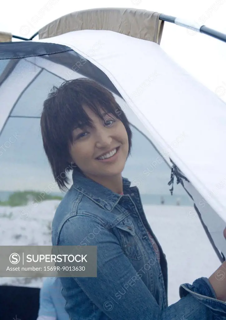 Woman standing in front of tent on beach