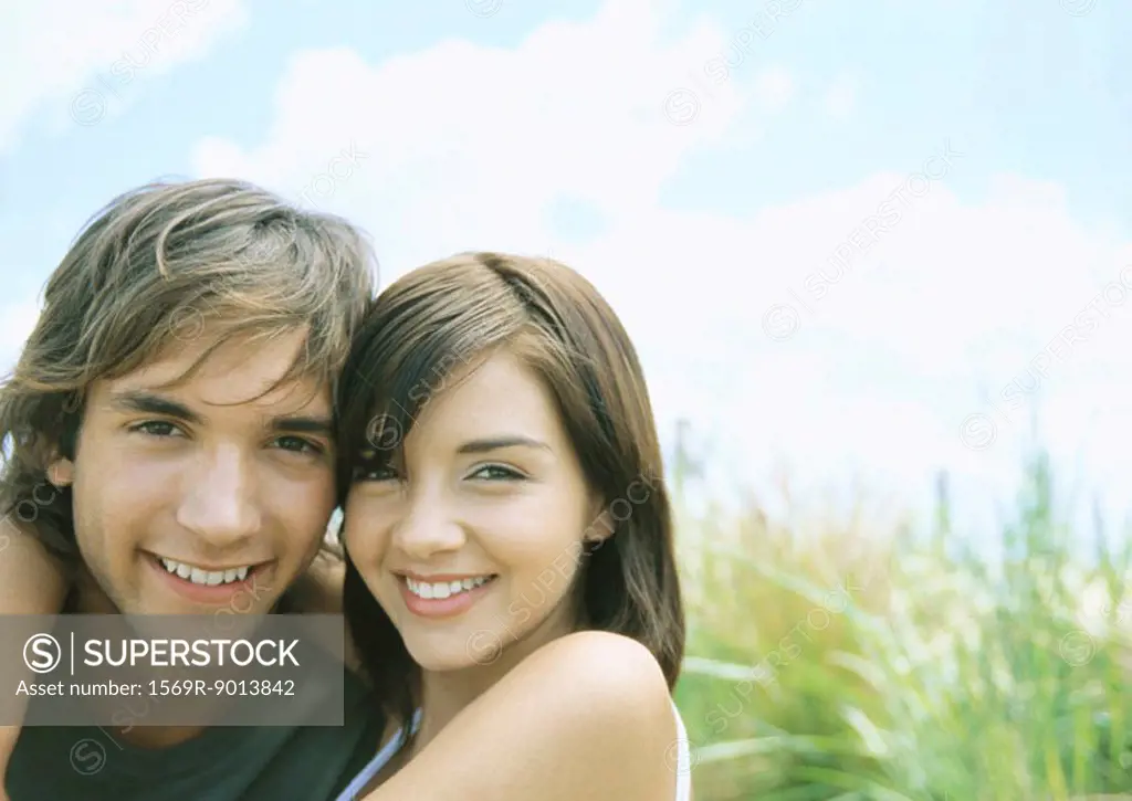 Young couple smiling, outdoors