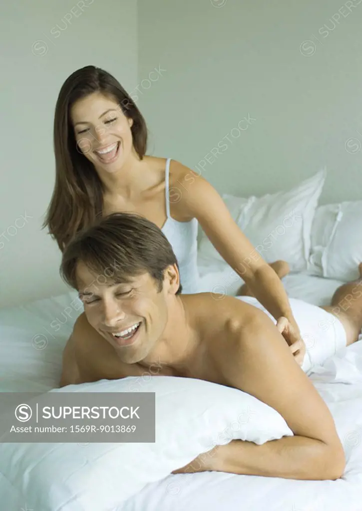 Woman tickling man in bed