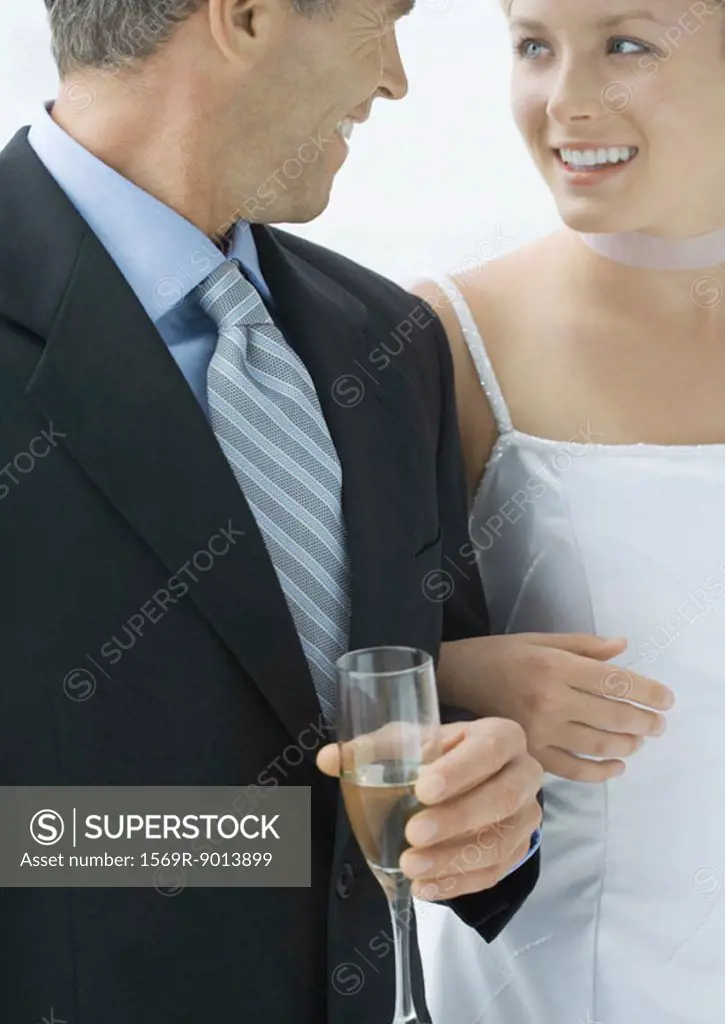 Bride standing arm in arm with father
