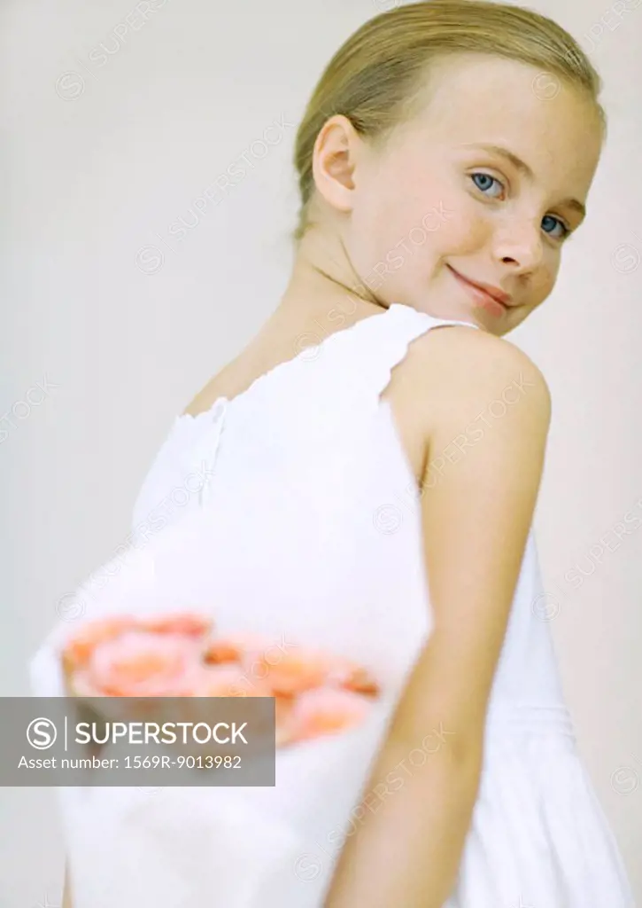 Girl holding bouquet of flowers behind back