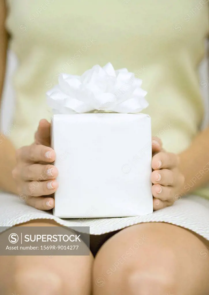 Woman holding present on lap, close-up