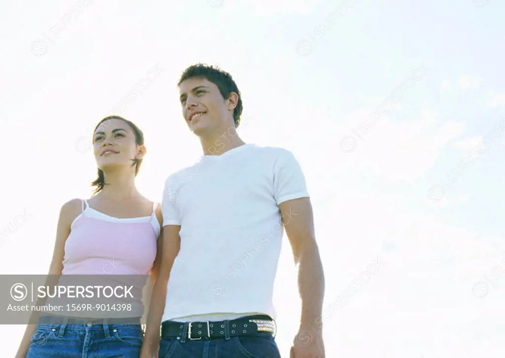 Young couple walking outdoors, front view
