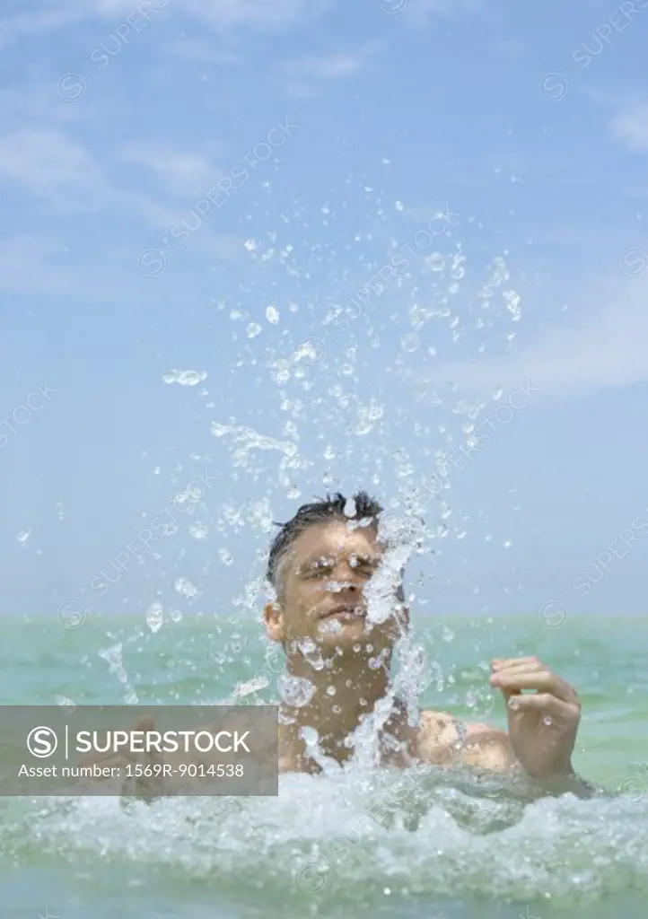 Man emerging from water, splashing