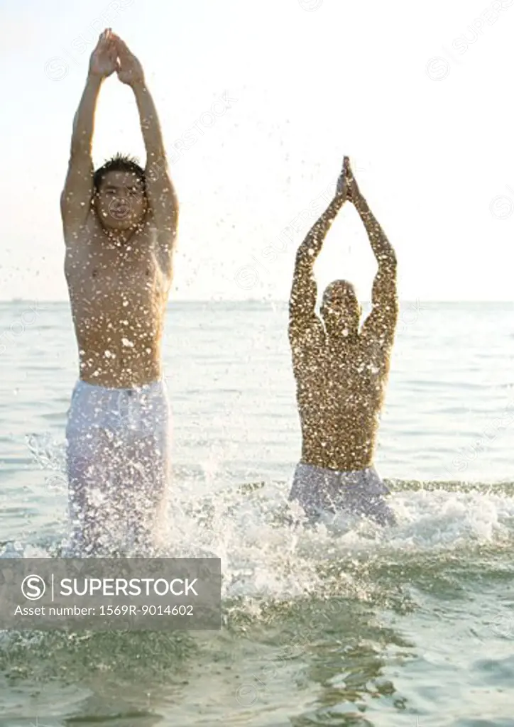 Two men emerging from water