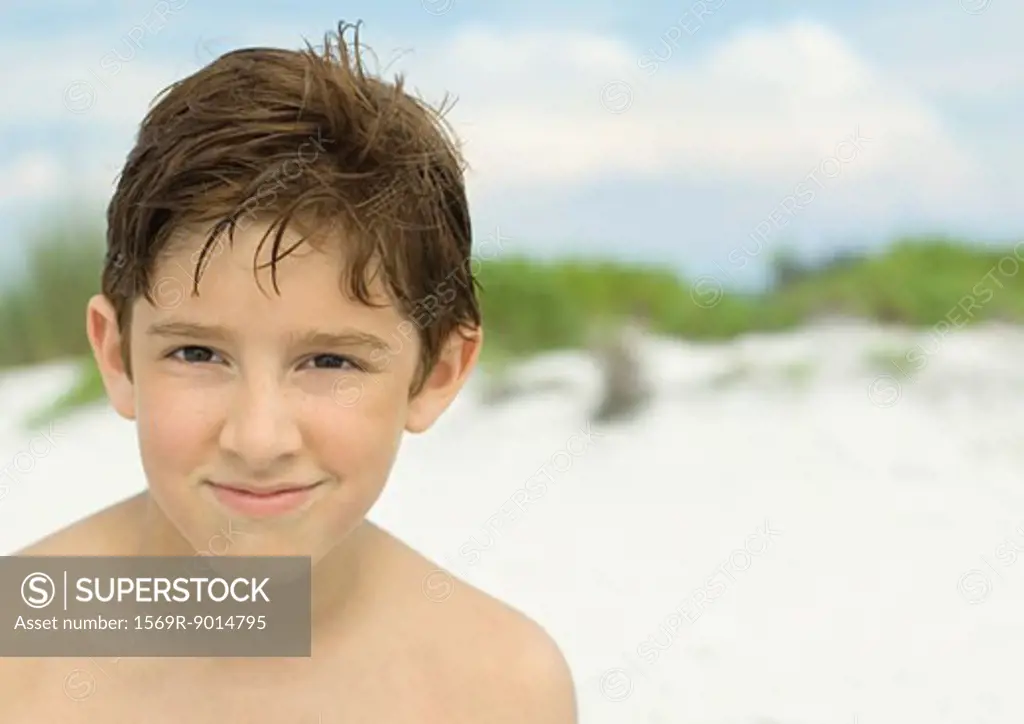 Boy smiling on beach, portrait