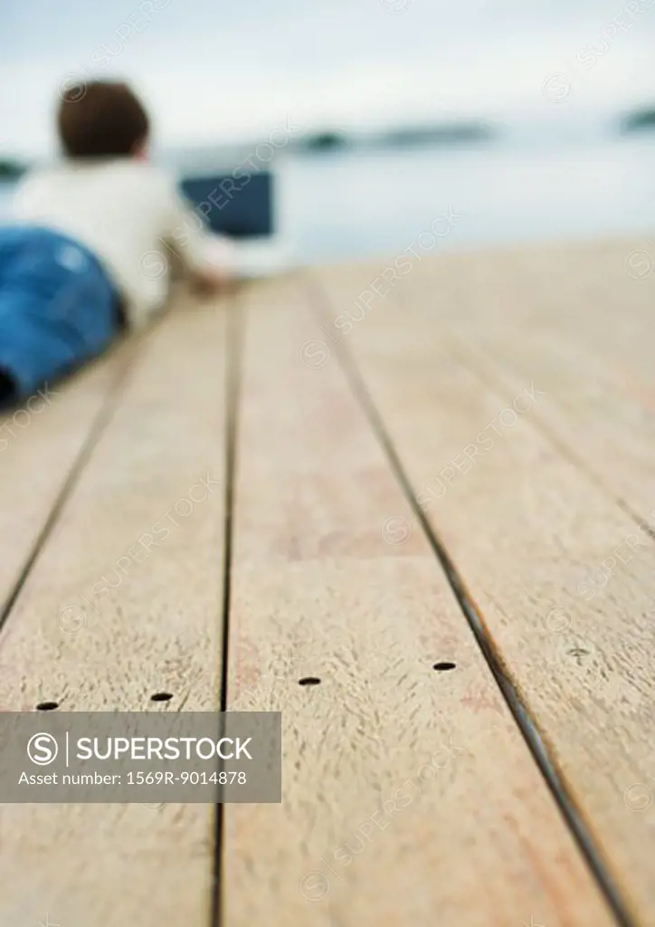 Child lying on dock