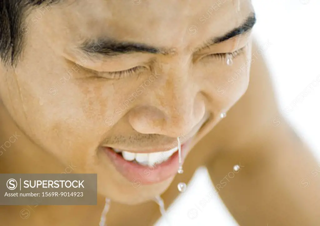 Young man with water dripping from face