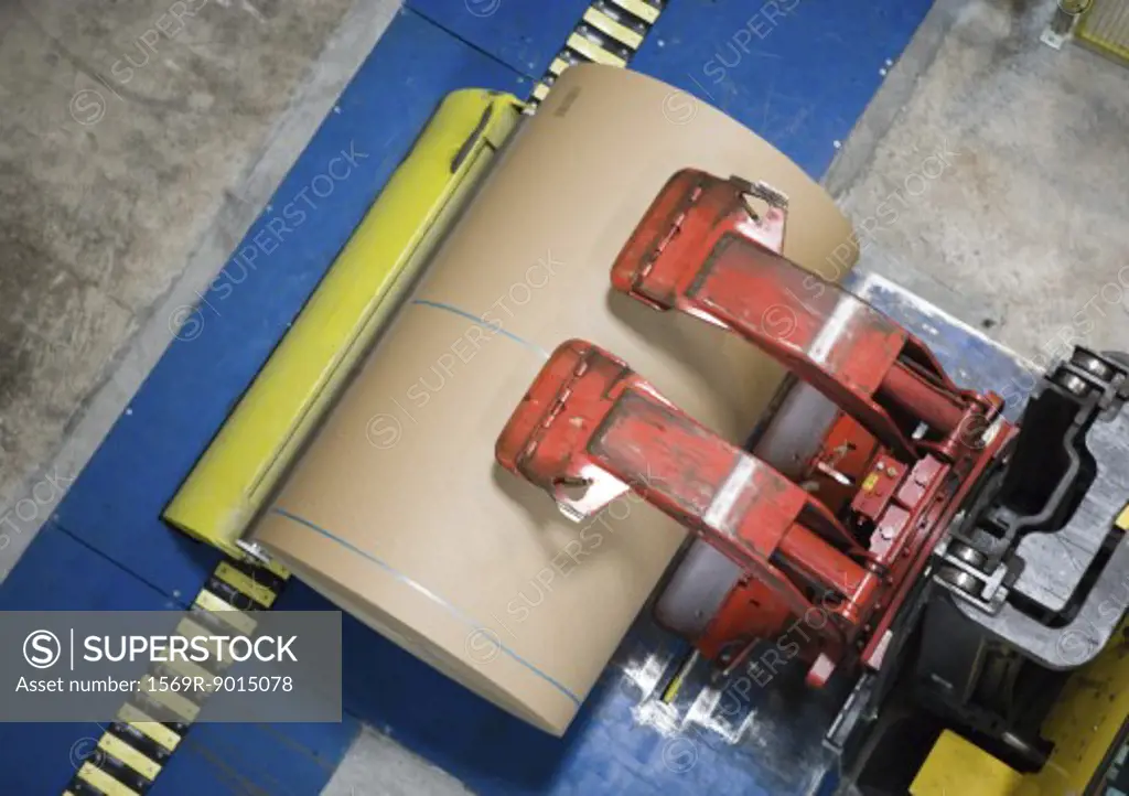 Fork lift picking up roll of paper