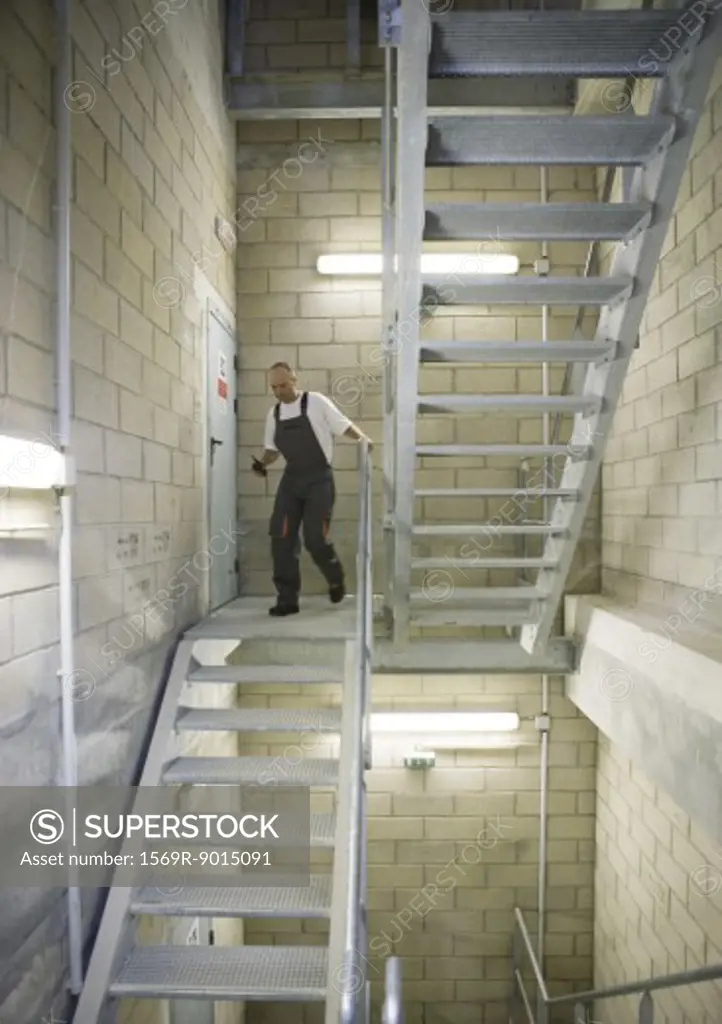 Factory worker walking down stairs