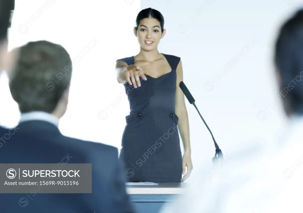 Businesswoman speaking with microphone during seminar