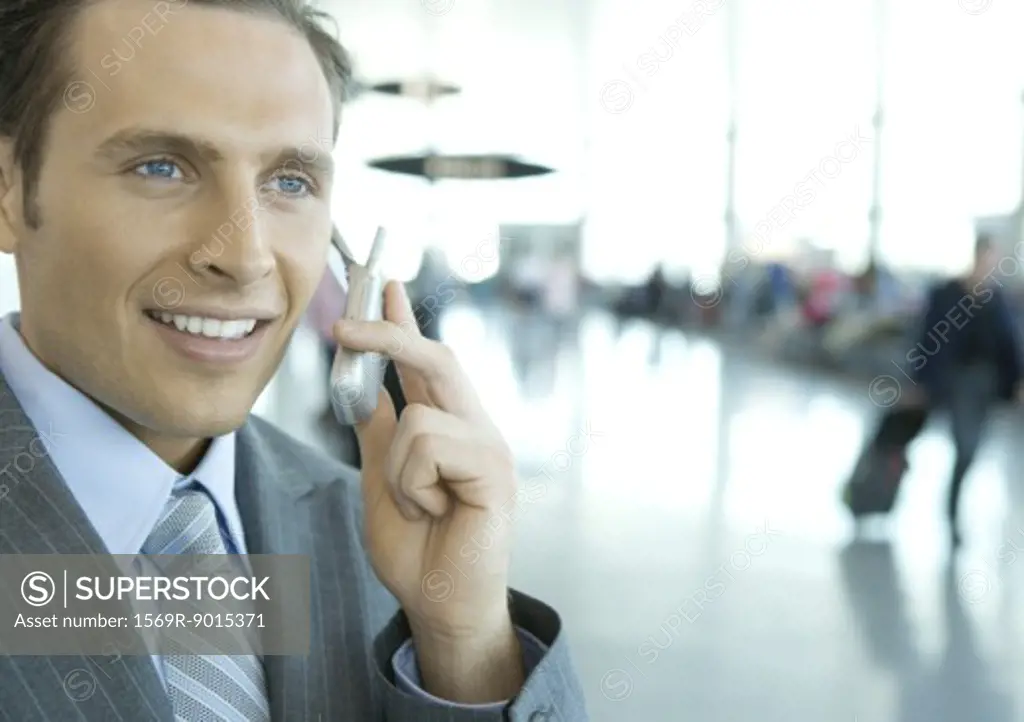 Businessman using cell phone in airport