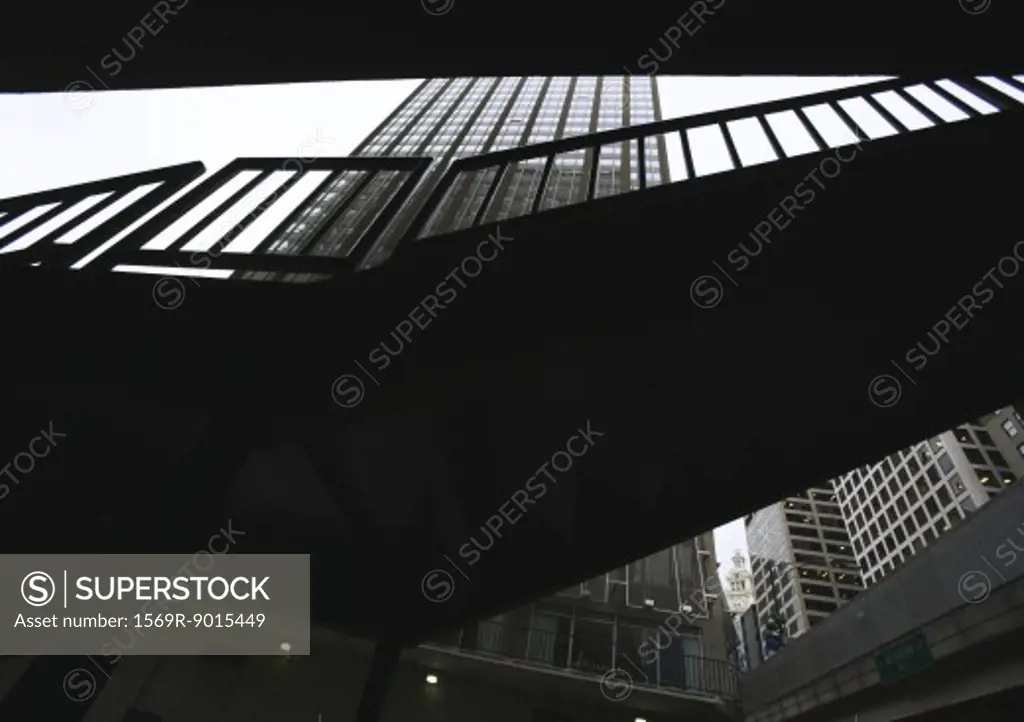 Silhouette of walkway and high rise building, low angle view