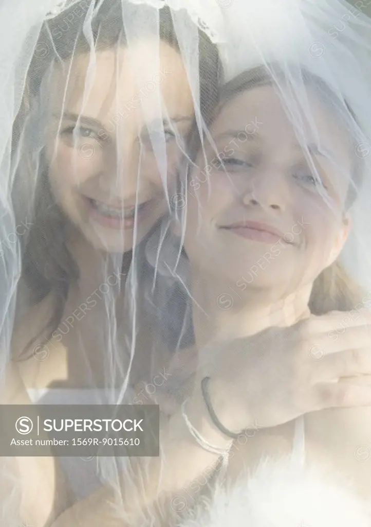 Preteen girls behind wedding veil