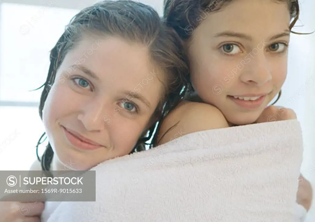Two preteen girls sharing towel