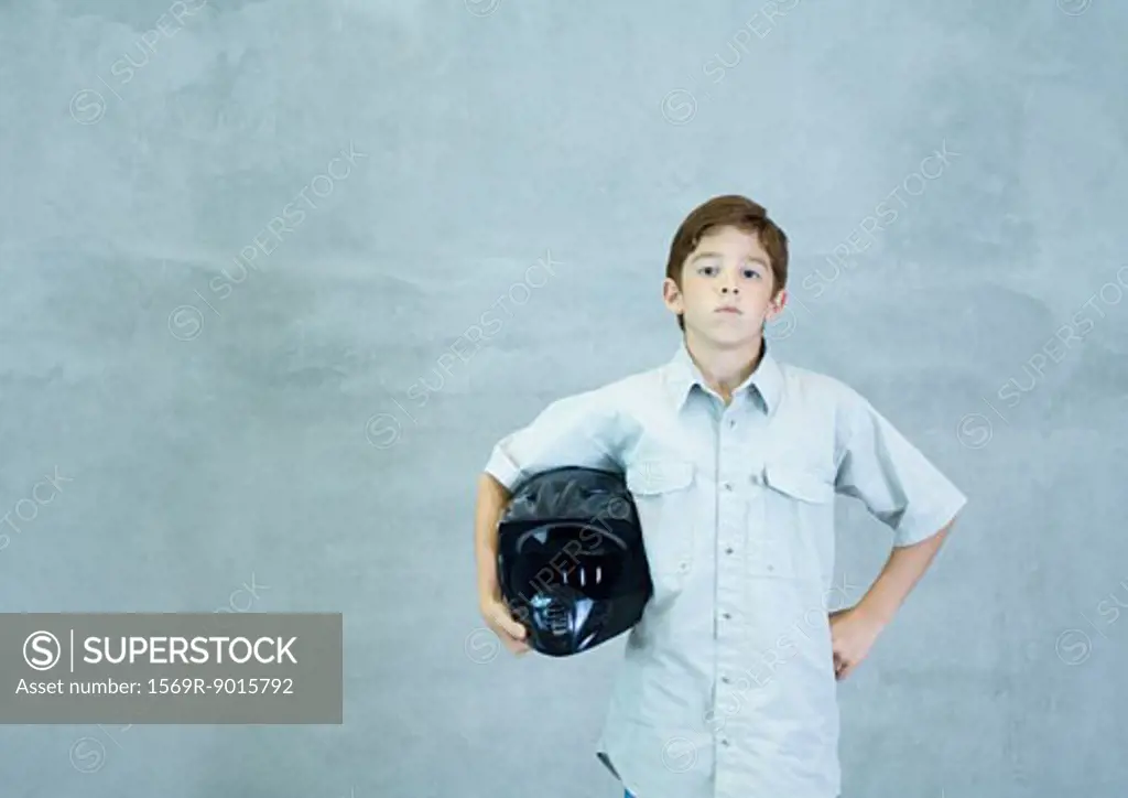 Boy standing with helmet under arm