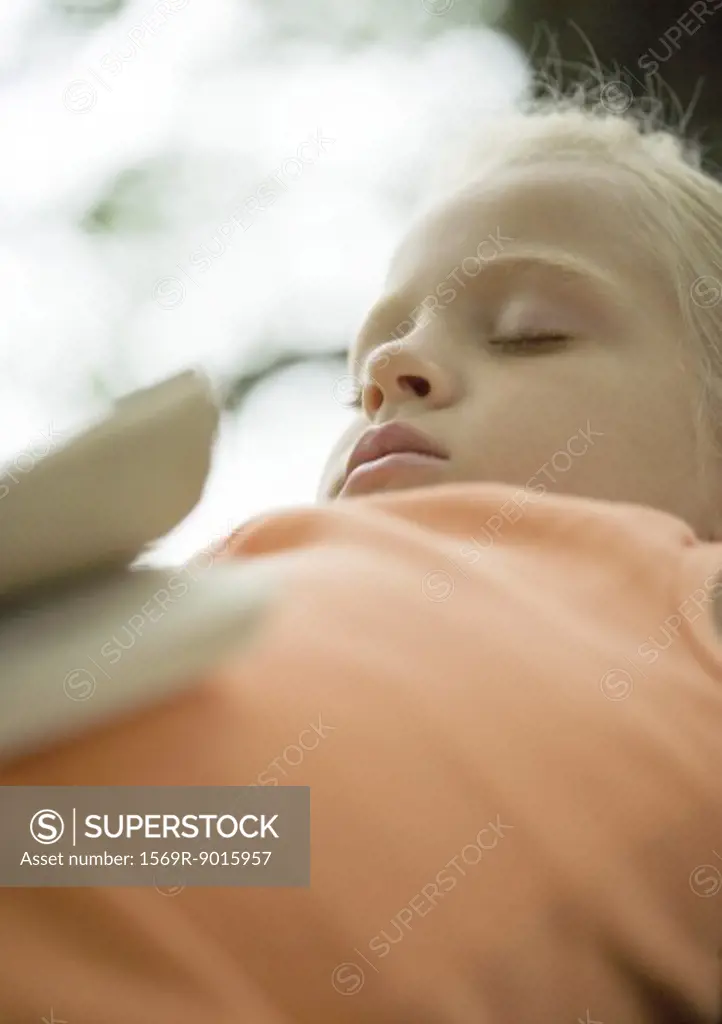 Girl sleeping with book on stomach