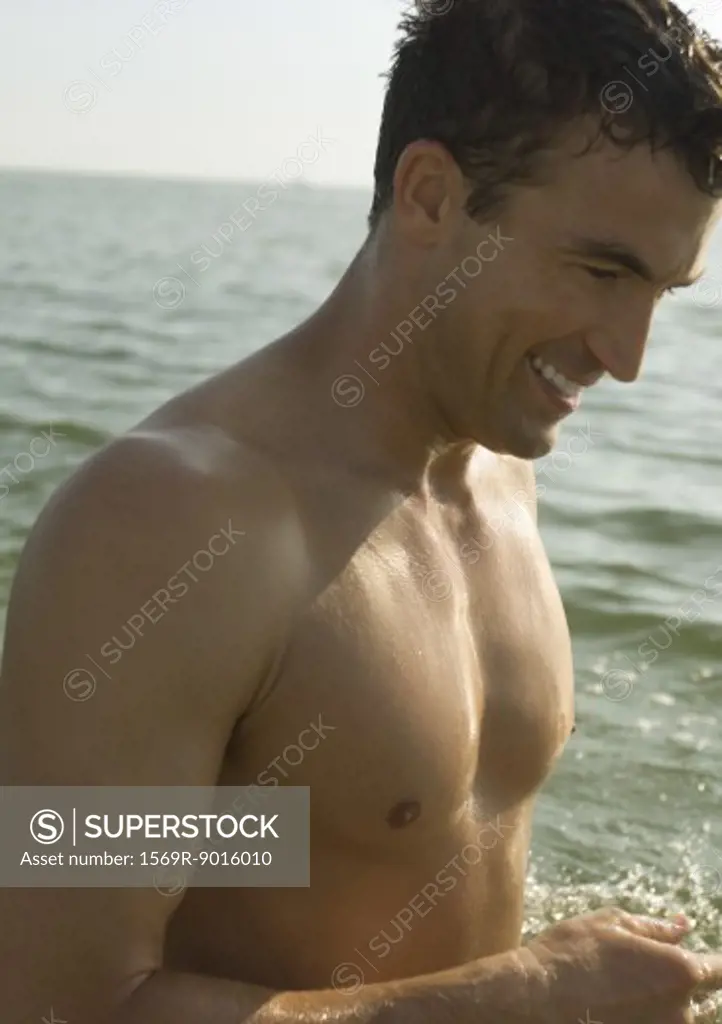 Barechested man, sea in background