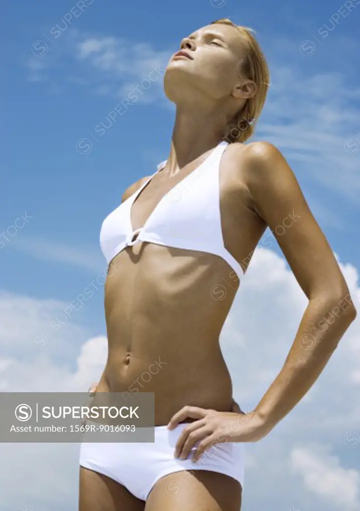 Woman standing in sun with eyes closed