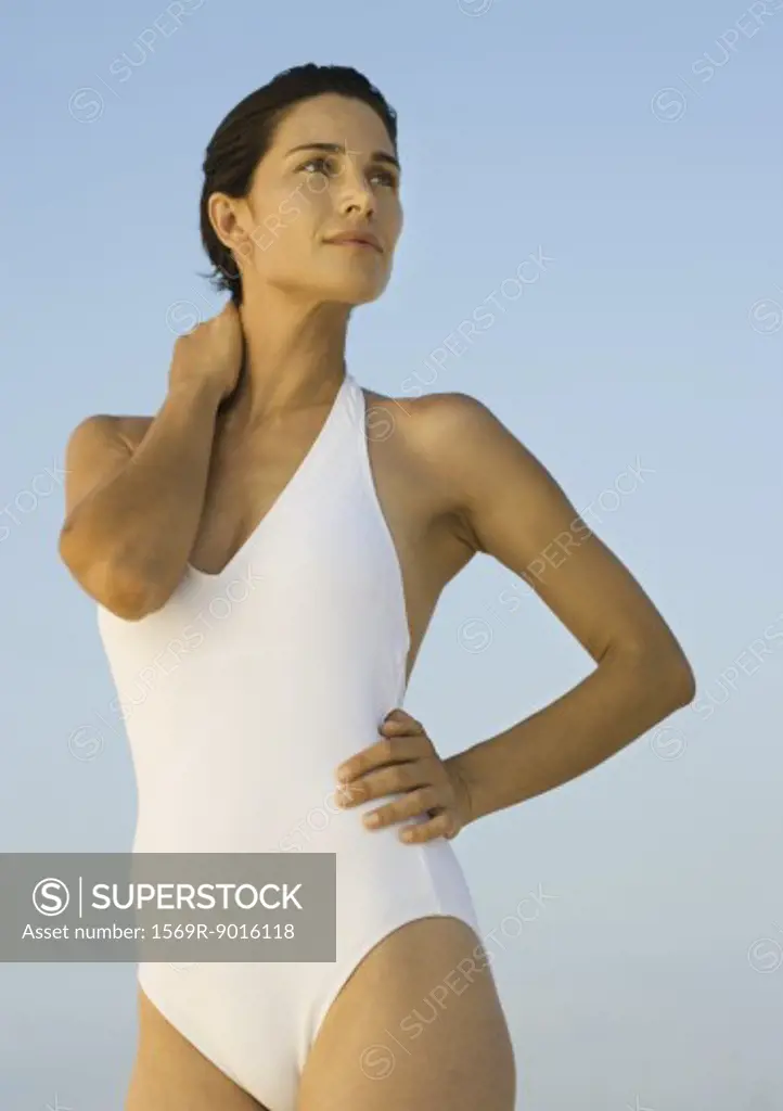 Woman in swimsuit standing, looking away