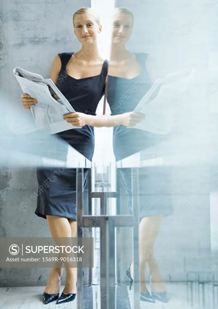 Businesswoman with newspaper, with reflection