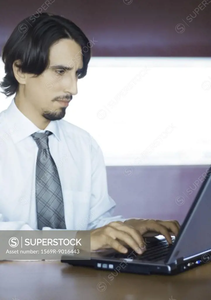 Businessman using laptop, portrait