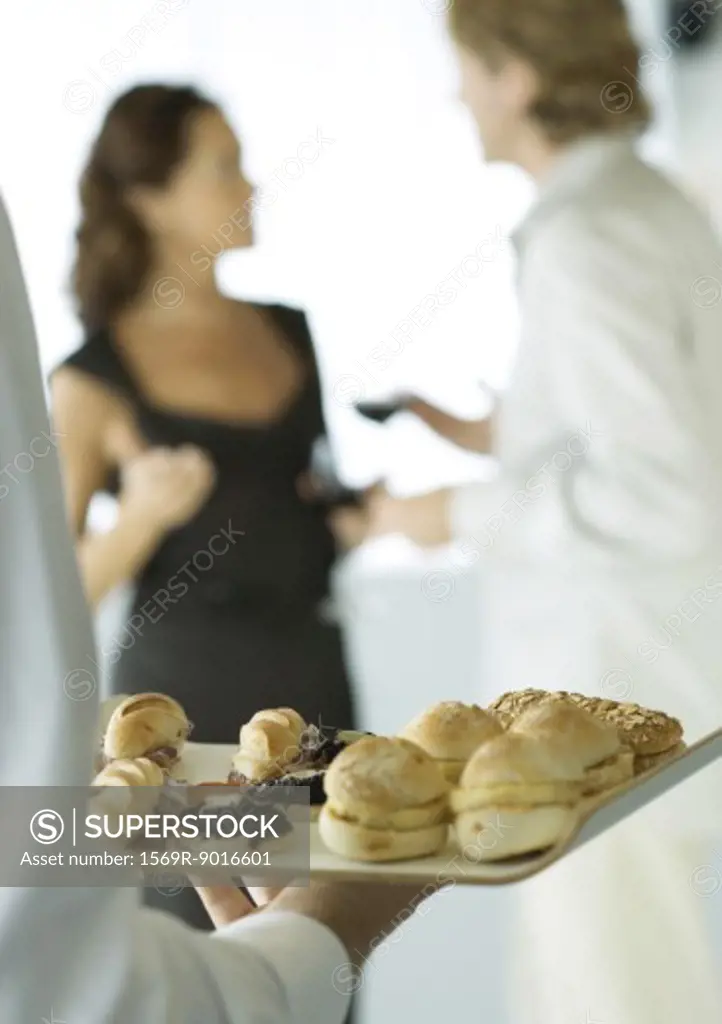 Server holding tray of appetizers during cocktail party