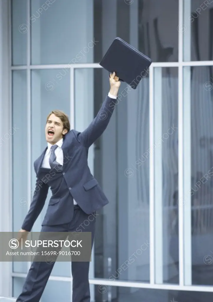 Businessman swinging briefcase and shouting