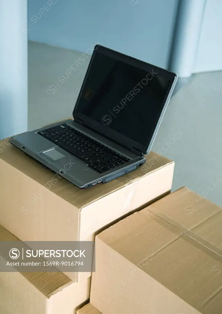 Open laptop on stack of cardboard boxes