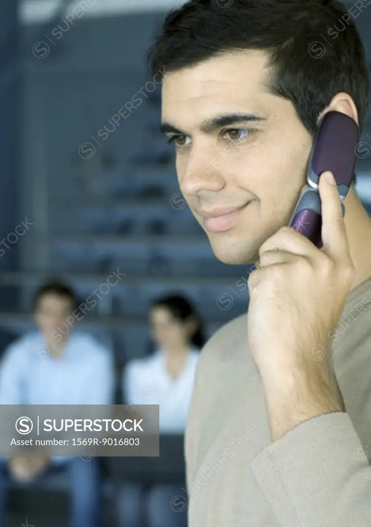 Man using cell phone, smiling