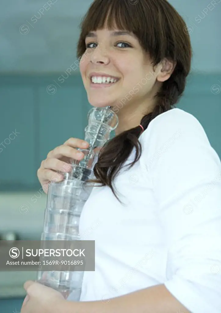 Girl holding stack of glasses, smiling