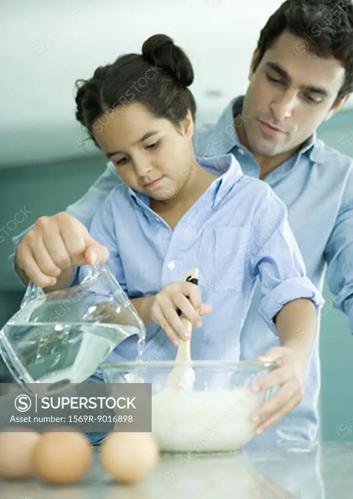 Father and daughter making batter together