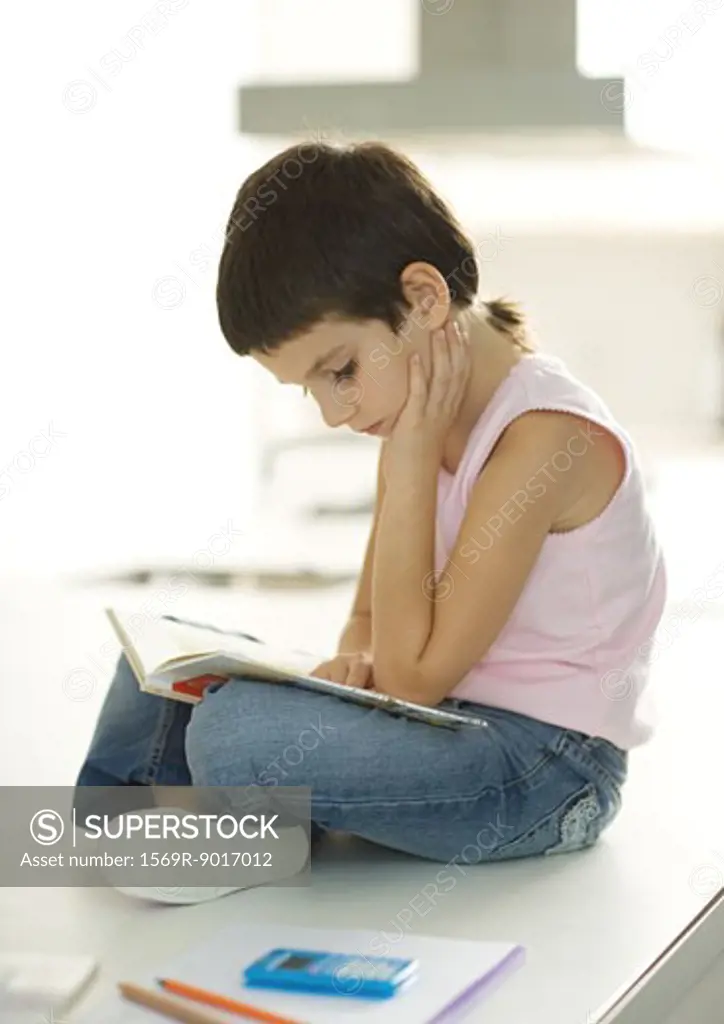 Child sitting, reading book