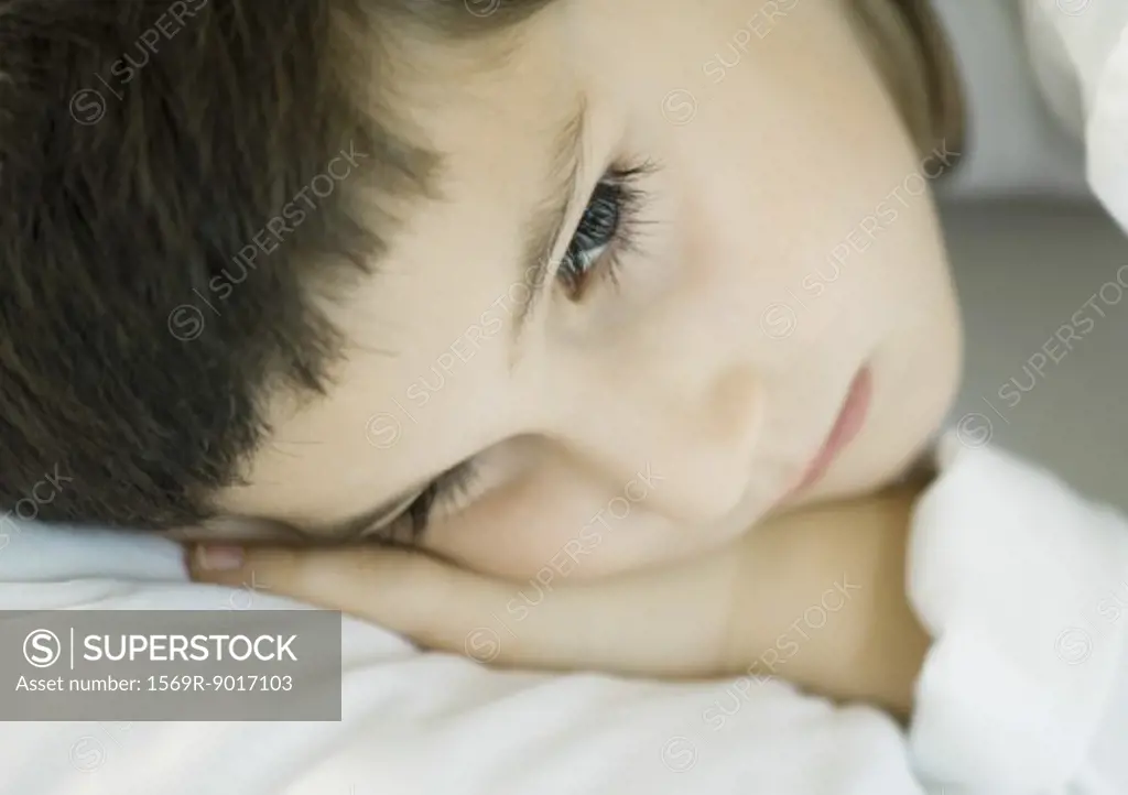 Child lying down, head on pillow, close-up