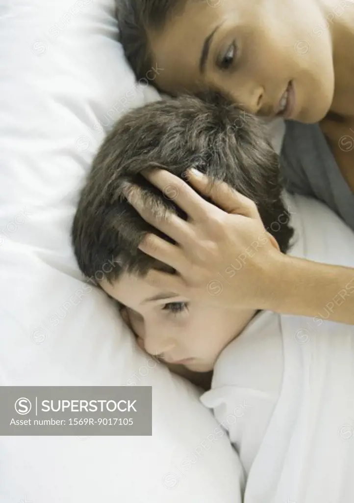 Child lying in bed with mother