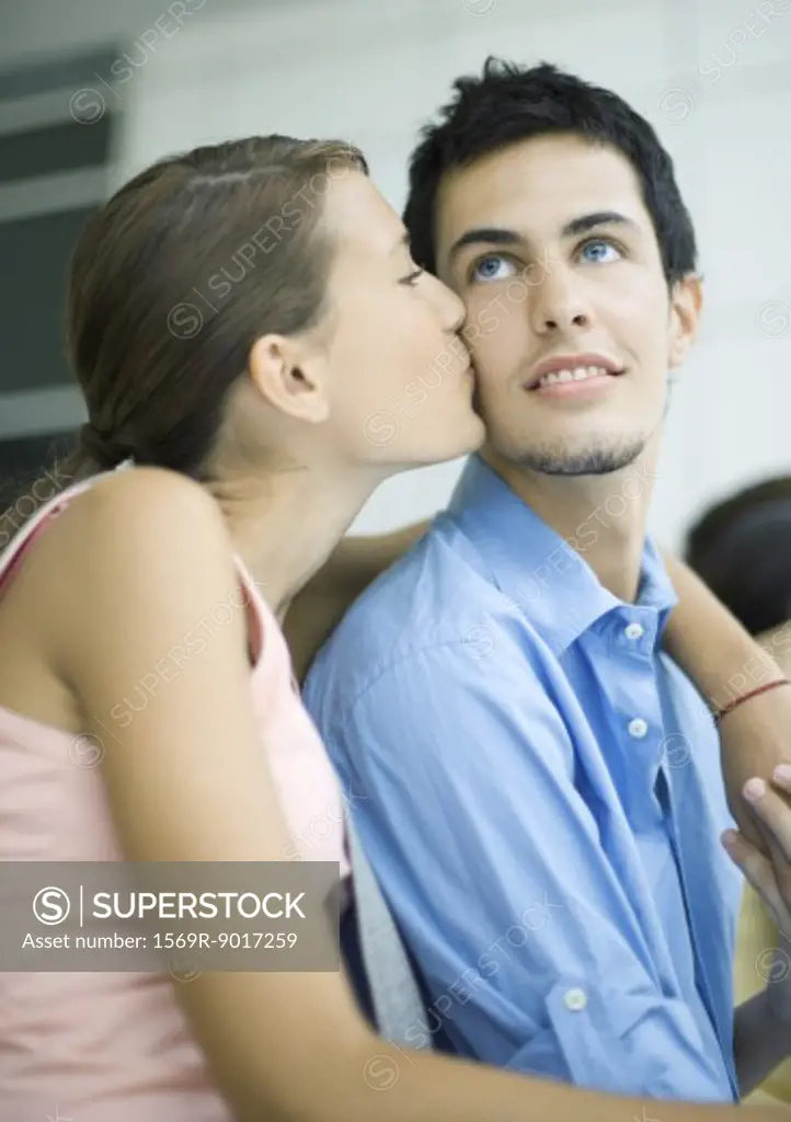 Teenage couple, girl kissing boy on cheek