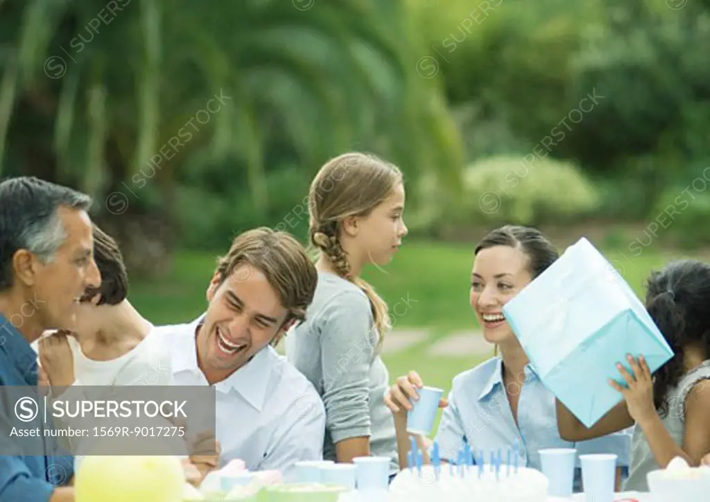 Outdoor birthday party, girl holding up present