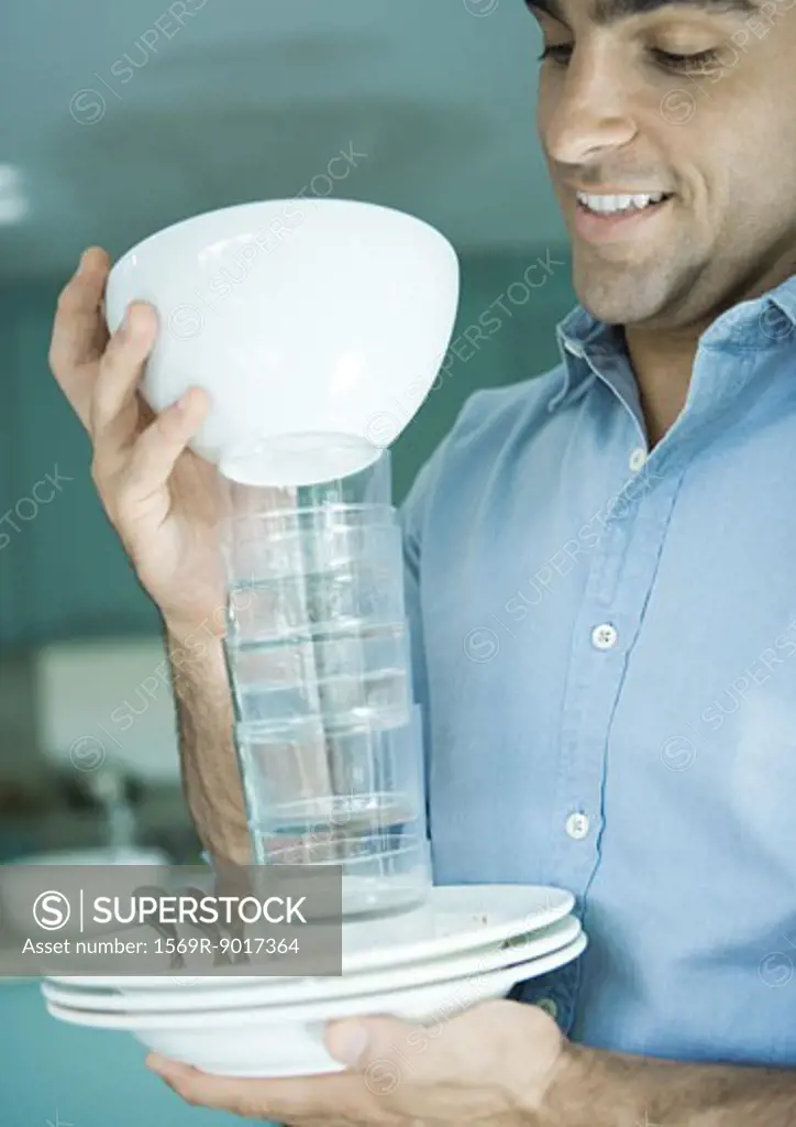 Man holding stack of dishes