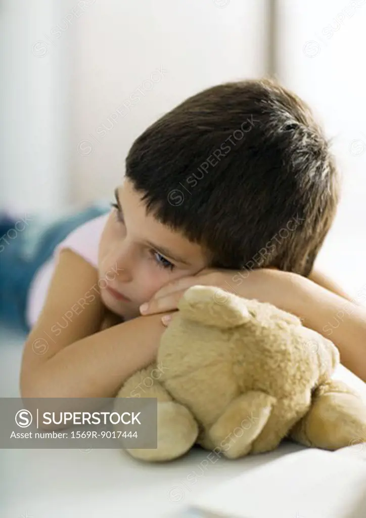 Child resting head on teddy bear