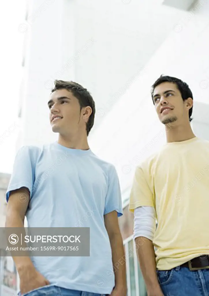 Two teen boys standing, looking out of frame