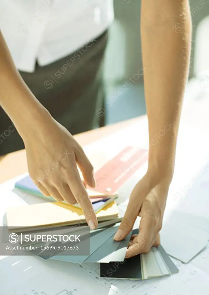 Woman pointing to color swatch, close-up of arms