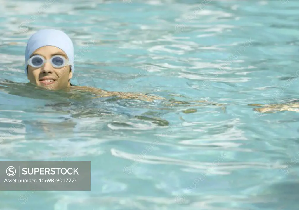 Person wearing bathing cap and goggles in pool