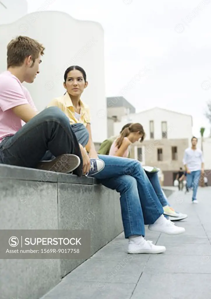 Teens sitting outdoors in urban area