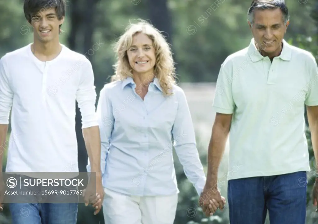 Mature couple holding hands with teenage grandson
