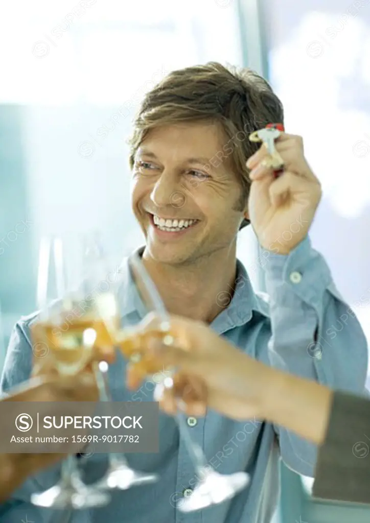 Glasses of champagne being clinked and man holding up keys, smiling