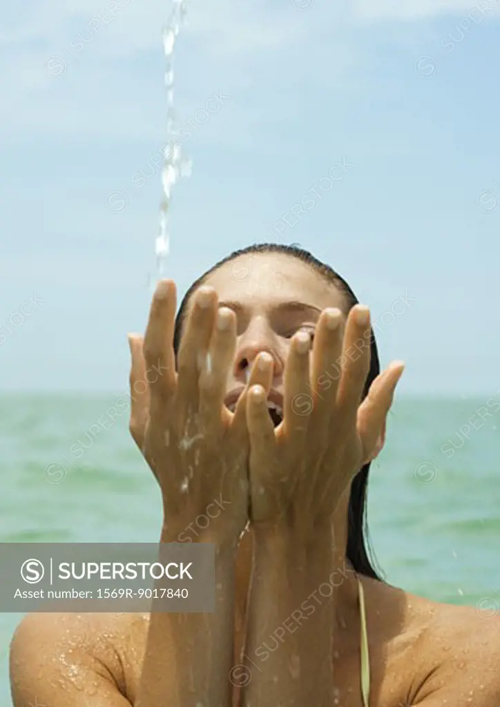 Woman in sea, splashing water with hands, close-up