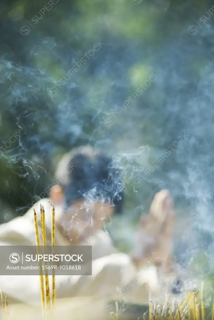 Incense burning, man in blurred background