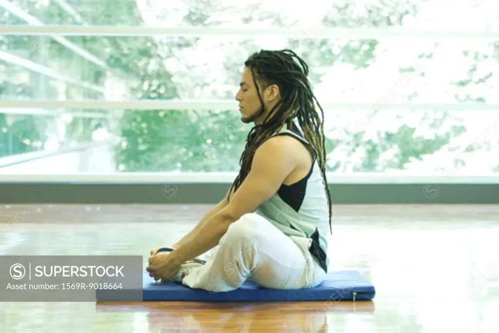 Man sitting in lotus position, side view