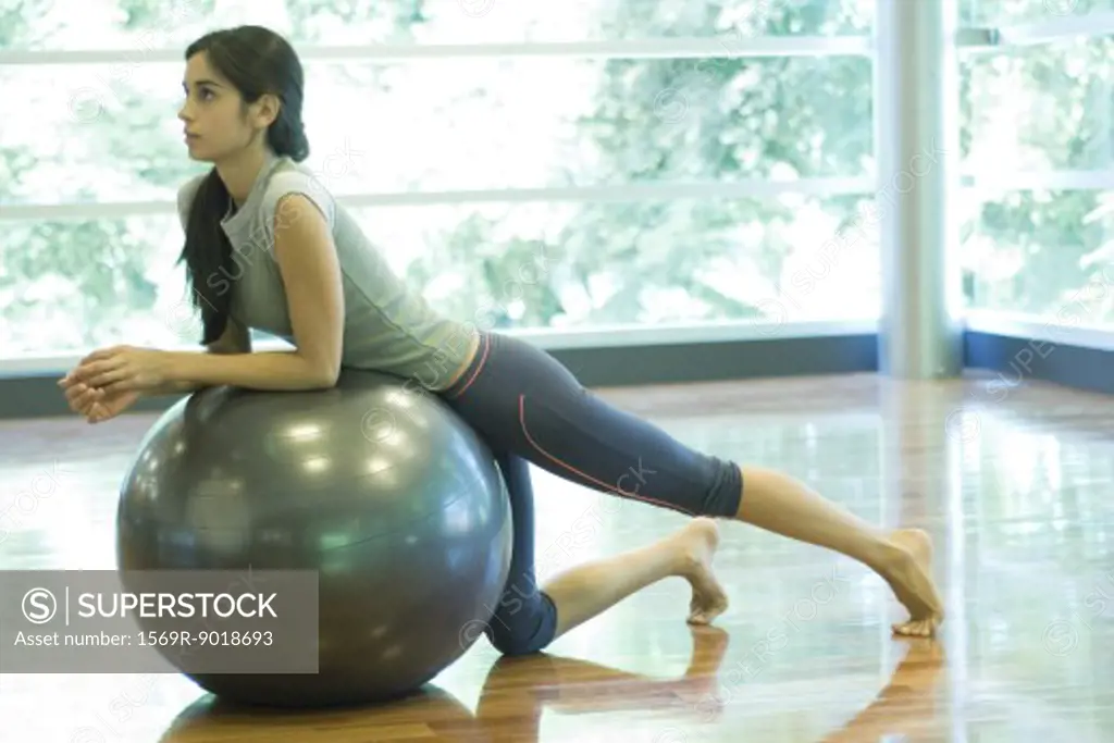 Young woman resting on fitness ball